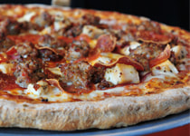 A picture of a Pizza Luce pizza covered in meat called The Bear.