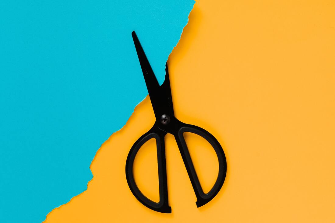 A photo of a scissors cutting paper, to represent Smith Nielsen coupons.